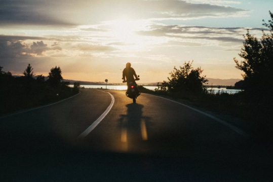 Motorcycle Driving down highway with a sunset view